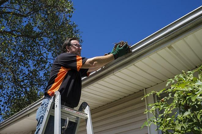 a technician replacing a section of damaged gutter in Bourbon